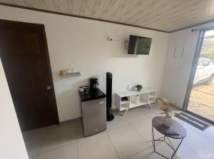 un salon avec une cafetière et une table dans l'établissement Zeus Guesthouse -Free SJO Airport Shuttle & Car Rental, à La Garita