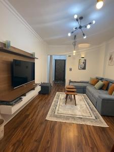 a living room with a couch and a flat screen tv at 1st Luxury and Hotel apartments super stylish AbourCity in El-Sa`âida