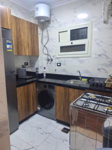 a kitchen with a sink and a washing machine at 1st Luxury and Hotel apartments super stylish AbourCity in El-Sa`âida
