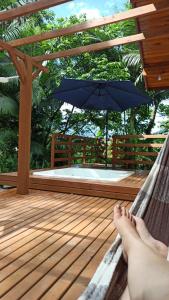 a person laying in a hammock with a blue umbrella at Recanto Schmidt in Aguas Mornas