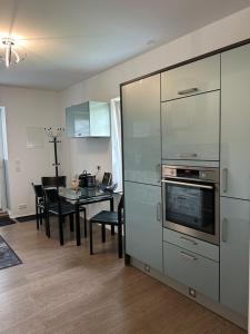 a kitchen and dining room with a table with chairs and a stove at Dorfperle in Oberzent