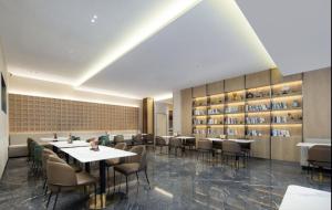 ein Esszimmer mit Tischen, Stühlen und Regalen in der Unterkunft Atour Hotel Jinhua Bayi South Street Subway Station in Chengnan