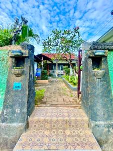 une porte menant à une maison avec une maison en arrière-plan dans l'établissement Sambu Bungalow, à Nusa Penida