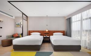 Postel nebo postele na pokoji v ubytování Hilton Garden Inn Xingyi Orange Hill Plaza