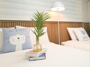 a table with a plant in a vase on a bed at Cozy Erin Stay, Seoul in Seoul