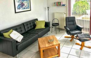 a living room with a black couch and a chair at 2 Bedroom Beautiful Home In Lemmer in Lemmer