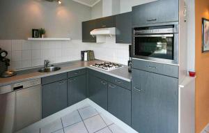 a kitchen with blue cabinets and a stove top oven at 2 Bedroom Beautiful Home In Lemmer in Lemmer