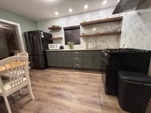 a kitchen with a black refrigerator and a table at The Woodward Unit A in Dahlonega