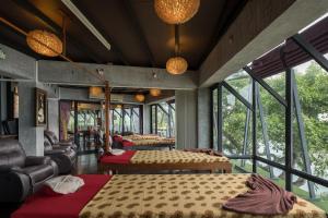 a room with four beds and chairs and windows at Panviman Resort Koh Phangan - SHA Extra Plus in Thong Nai Pan Noi