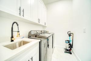 une cuisine avec un évier et un lave-vaisselle dans l'établissement Breezy Coral Escape-Heated Pool, à Cape Coral 25 autres photos