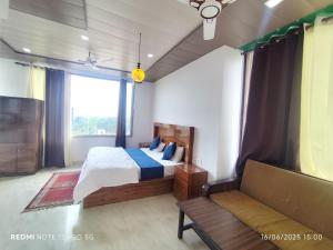 a bedroom with a bed and a couch at Green Dandi Homestay in Rāni Pokhri