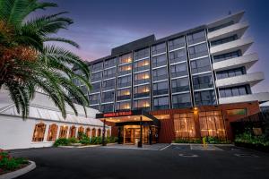 土乌巴Burke and Wills Hotel Toowoomba的一座前面有棕榈树的建筑