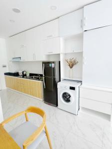 a white kitchen with a washing machine and a washer at ocean vista gio bien in Ấp Phú Tịnh (2)