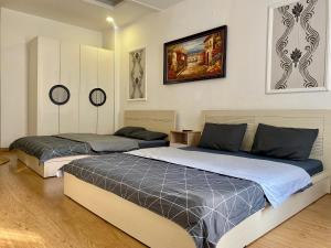 een slaapkamer met twee bedden en een schilderij aan de muur bij Mobylette Sai Gon in Ho Chi Minh-stad +25 foto's