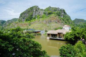 a river with a mountain in the background at Hang Mua Peaceful Retreat in Xuân Sơn