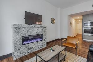 CozySuites Sky Central #24 في سينسيناتي: غرفة معيشة مع مدفأة وتلفزيون