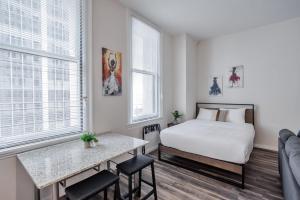 a bedroom with a bed and a table and chairs at CozySuites Sky Central #24 in Cincinnati +10 photos