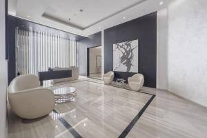a living room with two white chairs and a table at Damac Hills Carson studio on Golf Course in Dubai Marina +50 photos