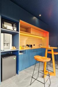 a kitchen with a wooden table and a stool at INNLUXPHUKET in Ban Laem Hin