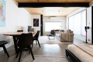 Bright Studio in Launceston CBD في Kings Park: غرفة معيشة مع طاولة وغرفة نوم