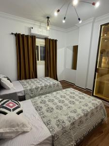a room with two beds in it with curtains at Tanta luxury apartments 2bed in Quḩāfah +31 photos