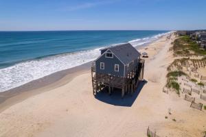 een blauw huis op een steiger aan het strand bij 7133 - Barefoot in Grun Island +86 foto's