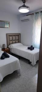 a bedroom with two beds with white sheets at Turisblo villa carmen in Benicarló