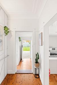 a hallway with white walls and wood floors and a doorway at Budget-Friendly Comfort - Private Single Room in Padstow - Shared Bathroom in Padstow