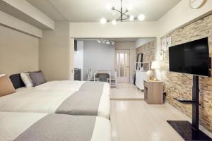 a bedroom with a large bed and a flat screen tv at Make Your Hotel Susukino A in Sapporo