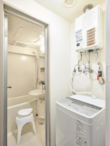 a bathroom with a washer and dryer and a sink at Make Your Hotel Susukino A in Sapporo