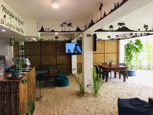 a restaurant with a table and a tv on a wall at Lagkaw Siargao Villas in General Luna