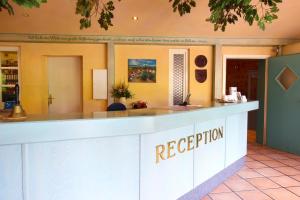 un bancone della reception in un hotel con le parole "accoglienza" di Hotel Burg-Mühle a Gelnhausen