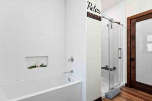 ein weißes Badezimmer mit Dusche und Badewanne in der Unterkunft Suite Ucluelet - Romantic Couples Getaway-Sauna! in Ucluelet