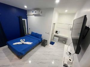 a bedroom with a blue bed and a bathroom at MJOY Resort in Taling Ngam Beach