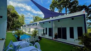 a white house with a swimming pool and lawn at MJOY Resort in Taling Ngam Beach