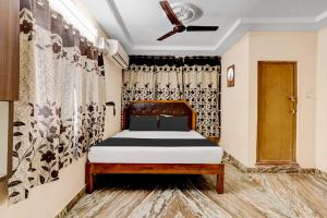 a bedroom with a bed and a curtain at Collection O Adarsh Nagar Near Kavya Hospital in Visakhapatnam