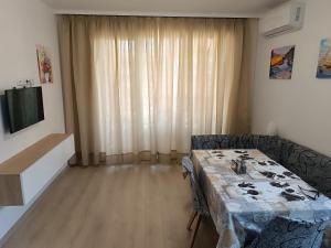 a dining room with a table and a television at Апартамент 11 улица Македония 33 Поморие in Pomorie