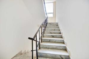 a staircase in a white building with a window at Collection O MVP Double Road in Visakhapatnam +22 photos
