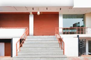 a staircase leading up to a building with a red door at Collection O MVP Double Road in Visakhapatnam