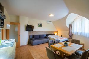 un soggiorno con un divano blu e un tavolo di Künszler Apartmanház a Zamárdi
