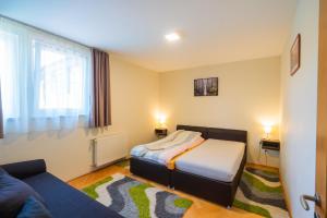 una piccola camera da letto con un letto e un divano di Künszler Apartmanház a Zamárdi Altre 27 foto