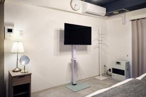 a bedroom with a flat screen tv on a wall at Make Your Hotel Susukino D in Sapporo
