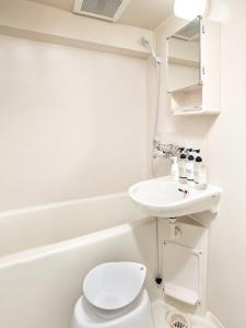 a white bathroom with a toilet and a sink at Make Your Hotel Susukino D in Sapporo +30 photos