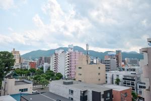 a view of a city with buildings and mountains at Make Your Hotel Susukino D in Sapporo
