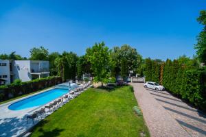 an estate with a swimming pool and a car at Künszler Apartmanház in Zamárdi