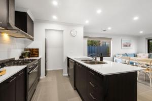 a kitchen with a sink and a stove top oven at Family-Friendly 4BR Mount Duneed Manor in Mount Duneed