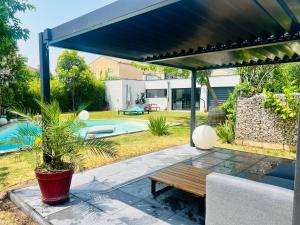 patio z drewnianym stołem i basenem w obiekcie Maison moderne Avignon 6 pers w Awinionie