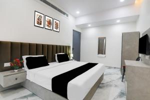 CharbaghSuper Collection O Quila Road Formerly JR Inn的一间带大床和电视的卧室