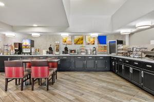 a large kitchen with black cabinets and red chairs at Comfort Inn & Suites Nashville Near Tanger Outlets I-24 Antioch in Antioch