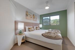 a bedroom with a large bed and a window at 2 BR Coastal Bliss Opposite Currumbin Beach in Gold Coast